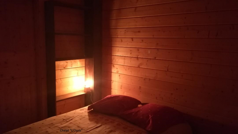 Chambre tout en bois, lit double, lampe de chevet allume