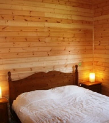 Chambre en bois, lit doubles, lampes de chevet allumes